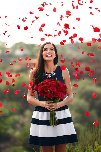 woman happy red roses petals rain love valentine's day